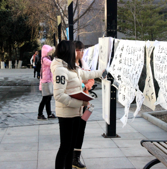 校园学生观看书画展作品